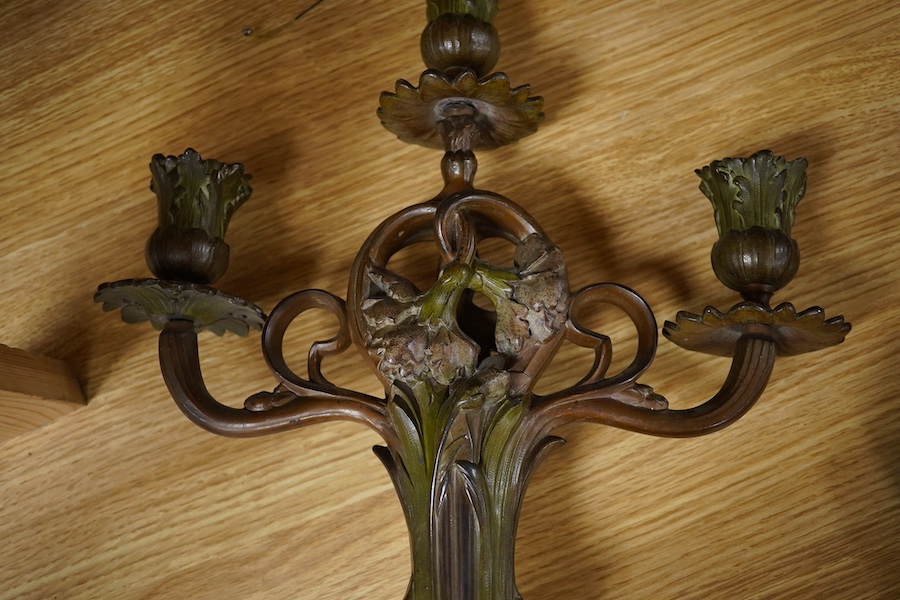 A pair of French patinated spelter floral painted Art Nouveau two branch, three light candelabra, 40cm high. Condition - good